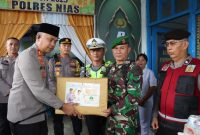 Kapolres Nias AKBP Revi Nurvelani, memberikan bingkisan kepada petugas yang berjaga di Pos Pelayanan dan Pos Pengamanan sebagai bentuk apresiasi. ISTIMEWA/BALUSENIAS.COM