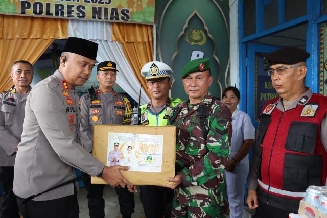Kapolres Nias AKBP Revi Nurvelani, memberikan bingkisan kepada petugas yang berjaga di Pos Pelayanan dan Pos Pengamanan sebagai bentuk apresiasi. ISTIMEWA/BALUSENIAS.COM