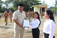 Bupati Nias Utara, Amizaro Waruwu, menyerahkan SK CPNS kepada 121 orang di halaman Kantor Bupati Nias Utara pada Senin, 14 April 2025. ISTIMEWA/BALUSENIAS.COM