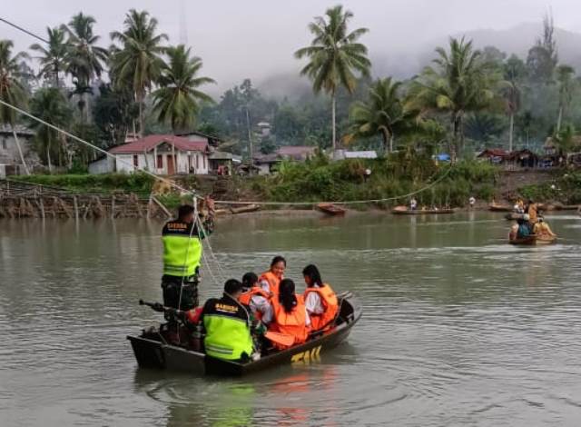 Dua personel Koramil 0213-08/Mandrehe menyeberangkan pelajar di Sungai Oyo, Desa Tuwuna, Kecamatan Mandrehe, Kabupaten Nias Barat. ISTIMEWA/BALUSENIAS.COM