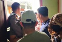 KR, wanita yang bersama dengan FID di dalam kamar kos, mengenakan masker dan sarung di kepala untuk menutupi jati dirinya saat digerebek oleh petugas dan warga setempat. ISTIMEWA/BALUSENIAS.COM