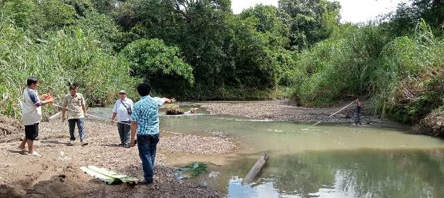 Kepala Desa Botona'ai, Sozanolo Gulo, bersama warganya mengukur lebar Sungai Na'ai di lokasi yang diharap akan dibangun sebuah jembatan. HASRAT HULU/BALUSENIAS.COM  