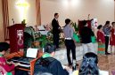 AKP Sonahami Lase menuntun seorang wanita tuna netra untuk menerima bingkisan kasih berupa sembako di Gereja BNKP Jemaat Onozikho pada Minggu, 29 Juni 2025. JOJOR MASIHOL MARITO/BALUSENIAS.COM