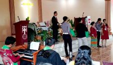 AKP Sonahami Lase menuntun seorang wanita tuna netra untuk menerima bingkisan kasih berupa sembako di Gereja BNKP Jemaat Onozikho pada Minggu, 29 Juni 2025. JOJOR MASIHOL MARITO/BALUSENIAS.COM