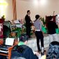 AKP Sonahami Lase menuntun seorang wanita tuna netra untuk menerima bingkisan kasih berupa sembako di Gereja BNKP Jemaat Onozikho pada Minggu, 29 Juni 2025. JOJOR MASIHOL MARITO/BALUSENIAS.COM