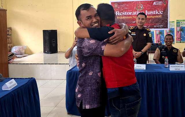 Berkat Aprianus Harefa berpelukan dengan tersangka OH yang telah meminta maaf dan mengaku menyesal atas perbuatannya. ISTIMEWA/BALUSENIAS.COM