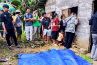 Warga Desa Sisarahili, Kecamatan Namohalu Esiwa mengerumuni rumah korban yang menjadi tempat kejadian perkara. ISTIMEWA/BALUSENIAS.COM 