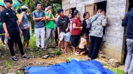Warga Desa Sisarahili, Kecamatan Namohalu Esiwa mengerumuni rumah korban yang menjadi tempat kejadian perkara. ISTIMEWA/BALUSENIAS.COM 