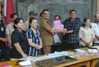 Penjabat Kepala Desa Sihare'o II Tabaloho, Yuliaman Harefa menerima dokumen RKPDes dari Ketua BPD, Fernius Mendrofa dalam Musyawarah Desa digelar pada Selasa, 7 Oktober 2025. SAROFATI LASE/BALUSENIAS.COM