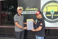 Ketua DPW LSM Garuda Nasional Provinsi Sumatera Utara, Hermansyah Telaumbanua, menunjukkan dokumen laporan pengaduan di Polres Nias pada Selasa, 7 Oktober 2025. SAROFATI LASE/BALUSENIAS.COM 