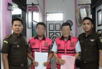 Yaredi Laoli dan Ehaogo Laoli selaku Kepala Desa dan Sekretaris Desa Tuhegeo II, masih tersenyum saat ditahan Jaksa pada Rabu, 14 Januari 2026. ISTIMEWA/BALUSENIAS.COM